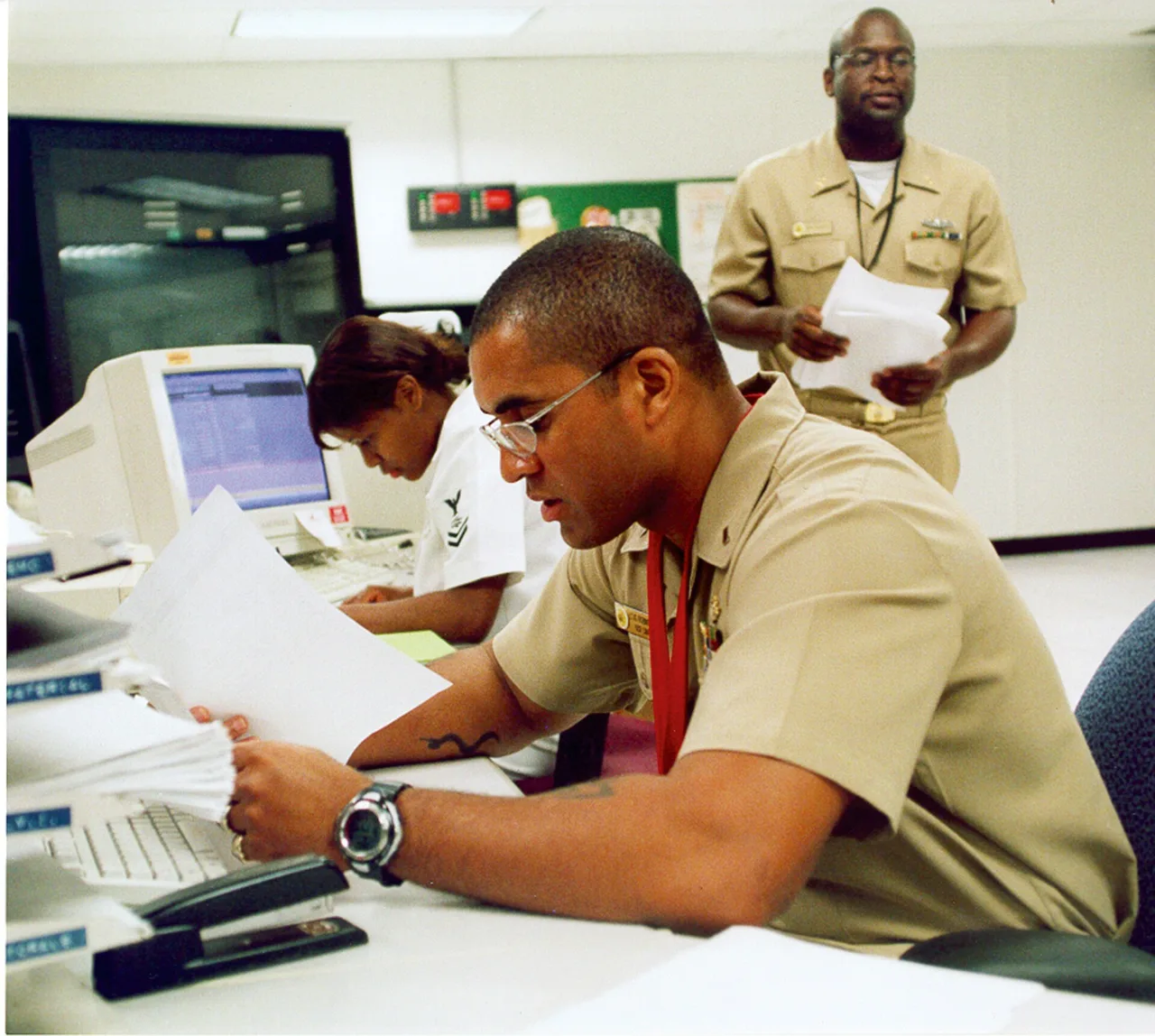 U.S. Navy personnel working at a message-center computer terminal in 2004